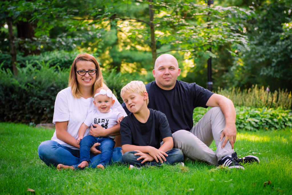 portrait family off four in green park