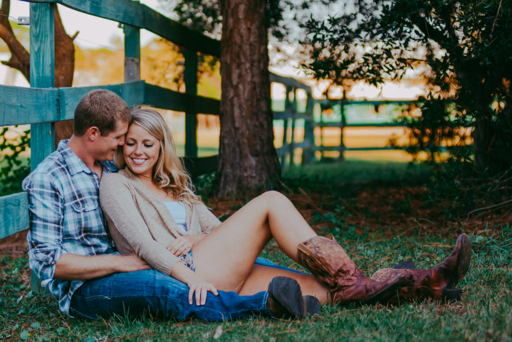 candid picture of the engagement couple sitting on the grass