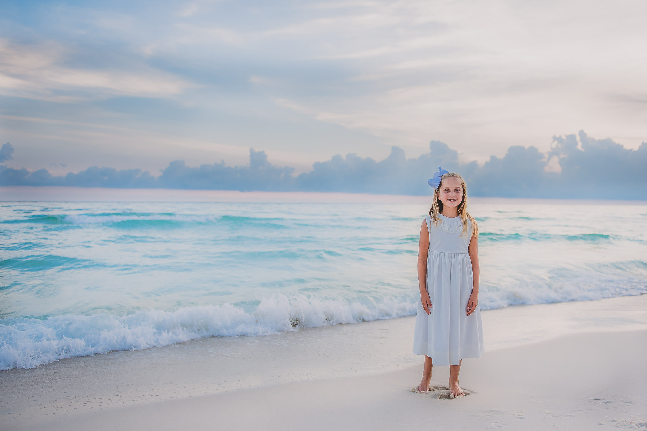 Young girl walking on the Sarasota beach with ocean wave as a background