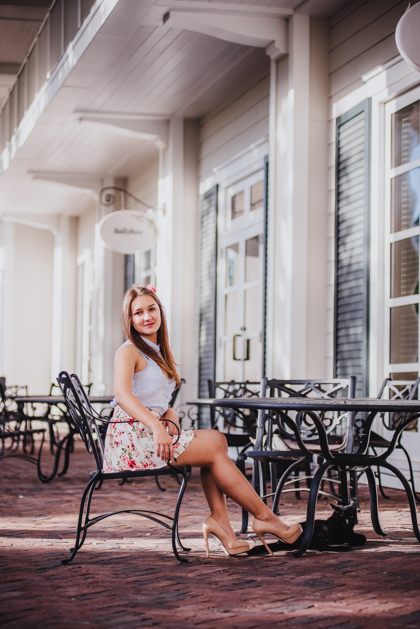 A senior portrait of dark hair girl sitting  in coffee shop