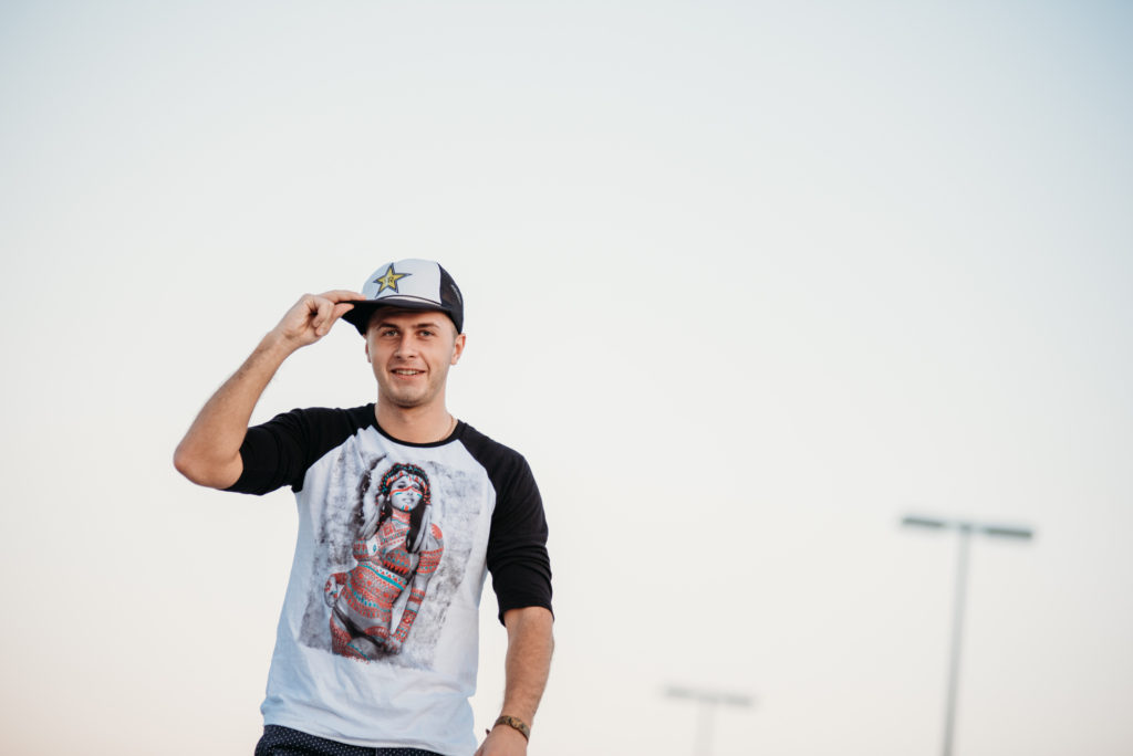 A portrait of high school senior boy wearing a baseball cap and t - shirt.