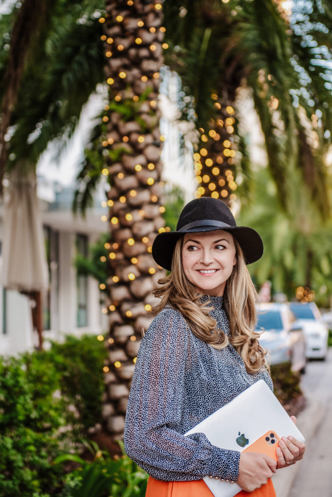 lifestyle portrait of  smiling women with the hat walking with the laptop