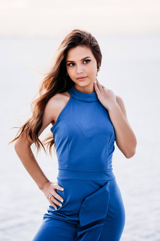 A young woman in a blue dress posing on the Siesta beach.