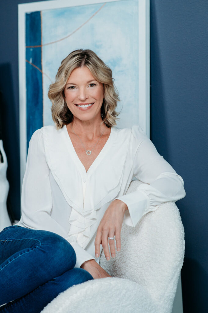 A life coach sitting in a chair in relaxing pose for her brand portrait