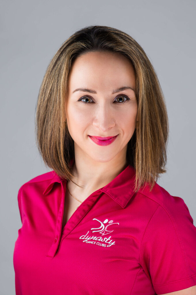 Commercial headshot of dance instructor wearing magenta company shirt with logo

