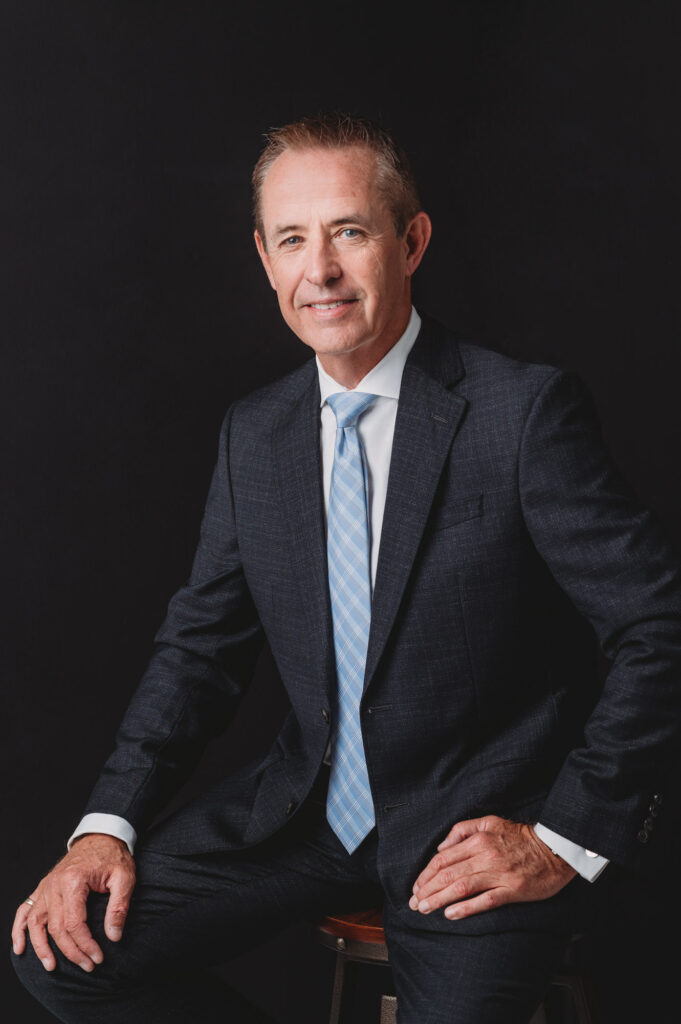 Linkedin headshot of middle age business men in dark suite on the black background