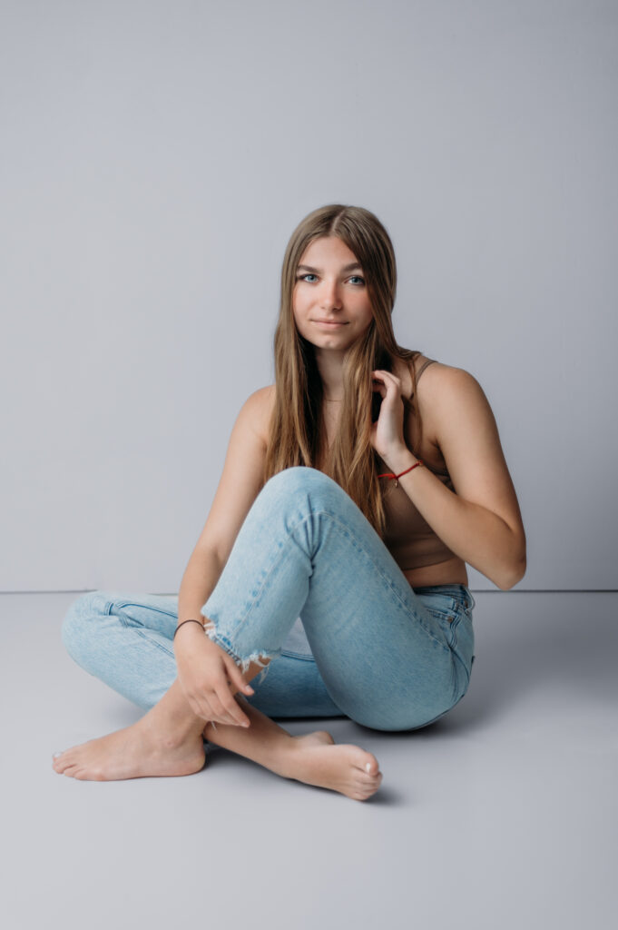 Modern senior portrait of high school senior girl in studio with white background