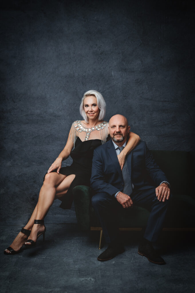 A modern portrait of a mid age couple in formal clothing posing at a portrait studio.