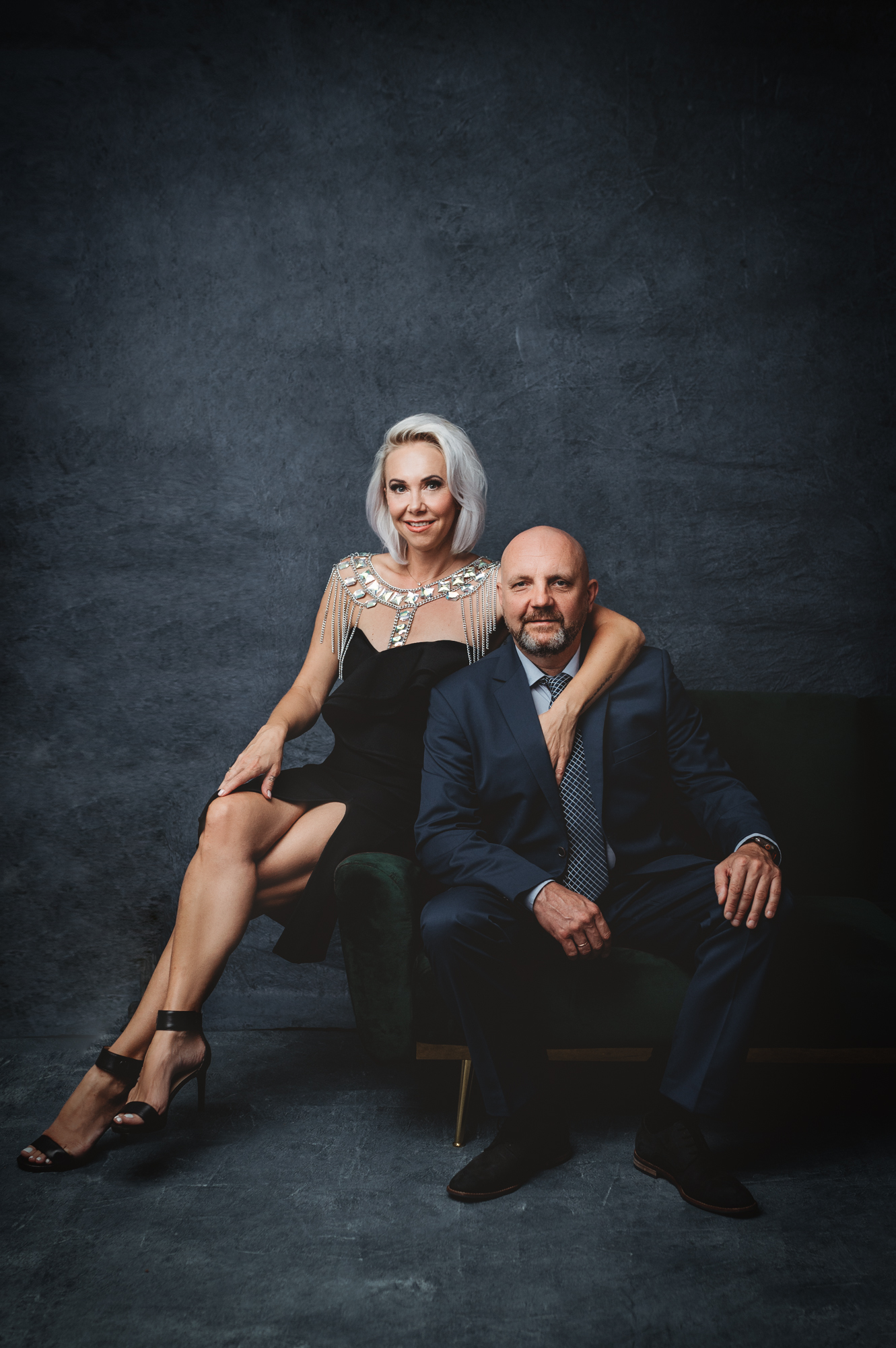 A modern portrait of a mid age couple in formal clothing posing at a portrait studio.