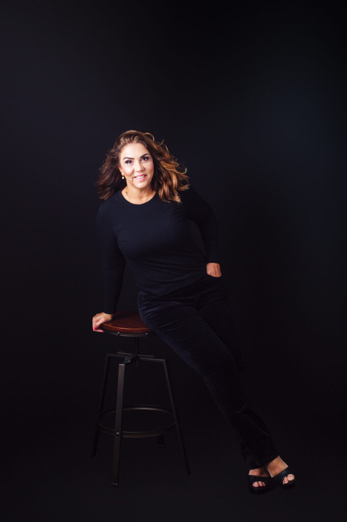 A woman sitting on a stool, captured in captivating Sarasota personal branding photography.