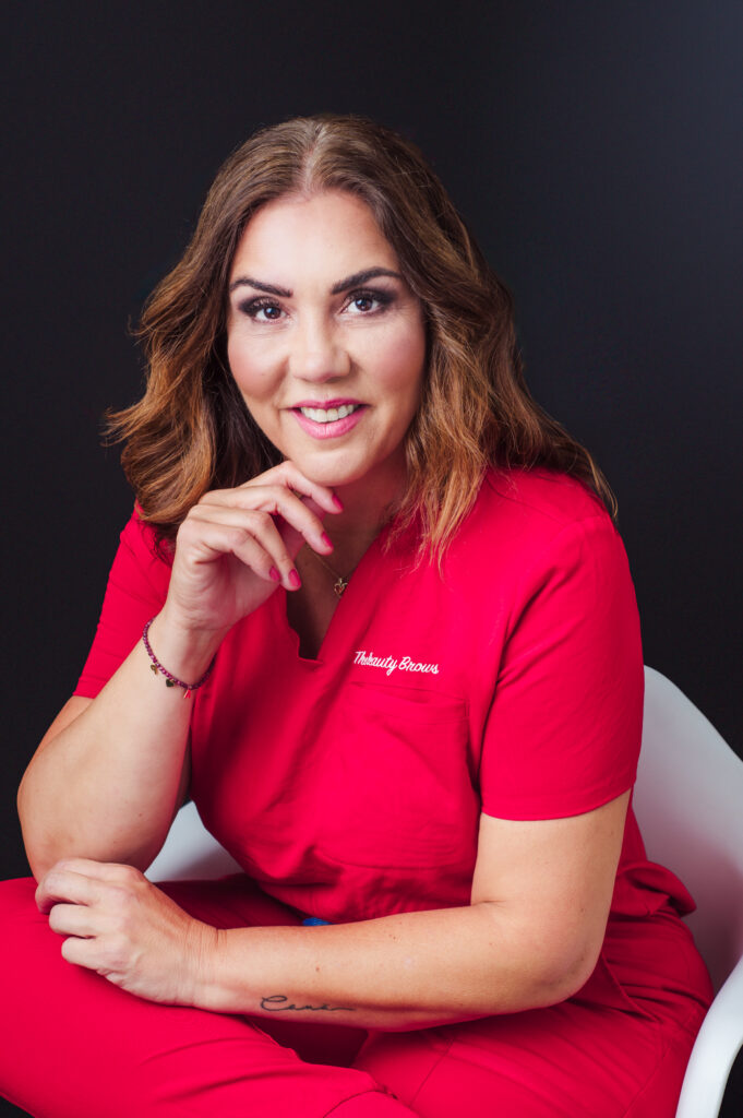 A woman in red scrubs striking a pose for a photo during a personal branding photography session in Sarasota.