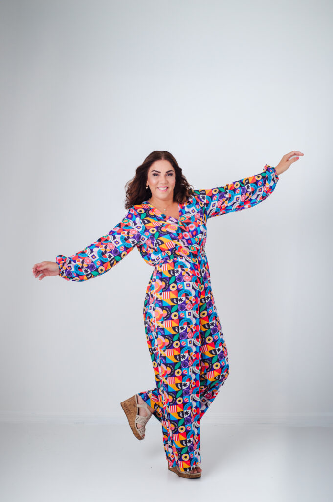A woman is posing in a vibrant jumpsuit for Sarasota personal branding photography.