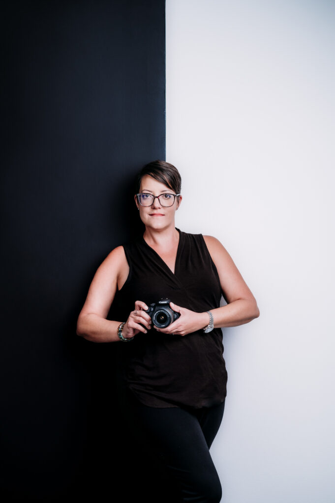 A Sarasota brand photographer capturing personal branding photography of a woman in front of a black and white wall.