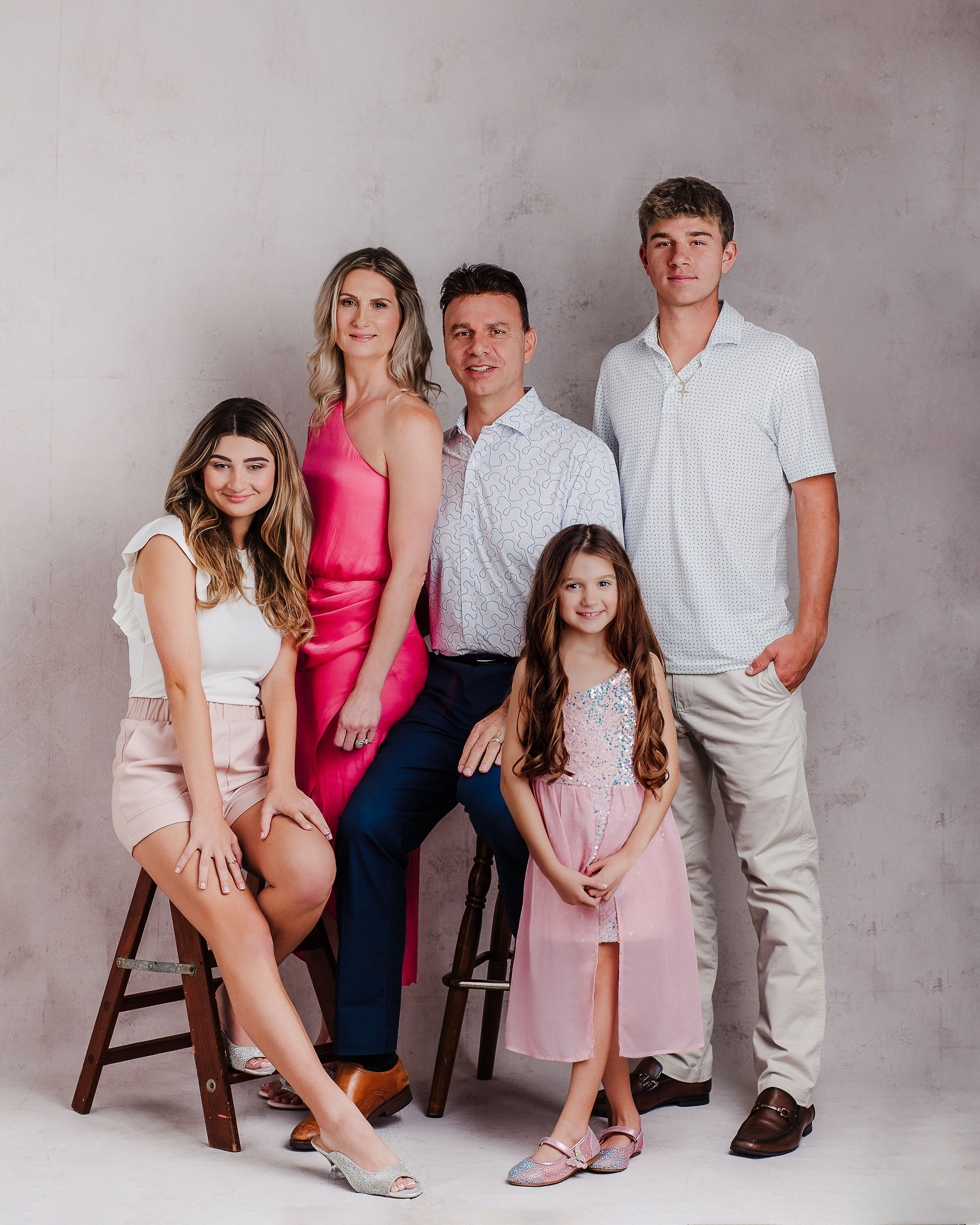 Modern studio family portrait of family of five dress in elegant casual outfits