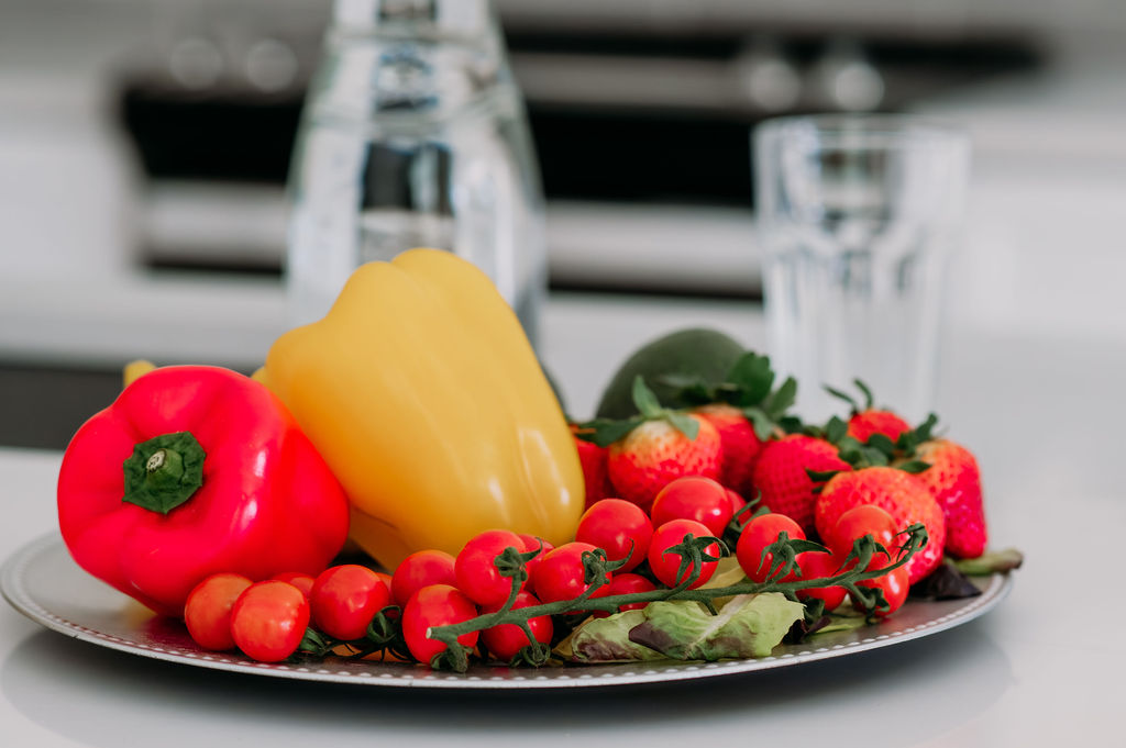 Close up of the plate full of tomatoes, peppers and strowberries