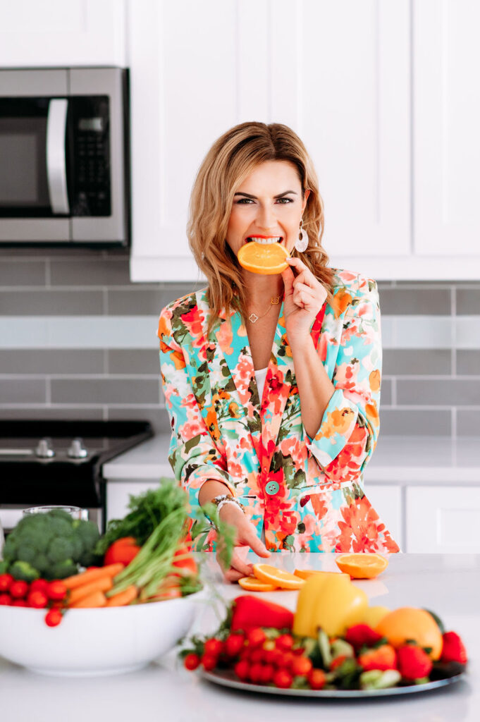 brand photo of the women in flowery jacket eating oranges