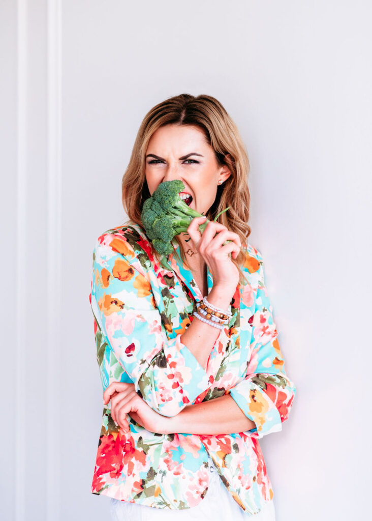 Brand photo of the women in flowery jacket eating broccoli