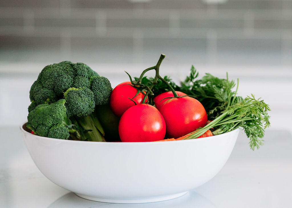 Bowl full of broccoli, carrots and tomatoes