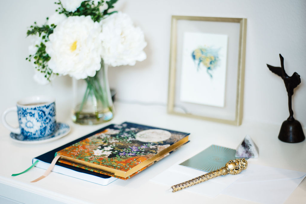 A lifestyle product image featuring two elegantly designed notebooks accompanied by a matching gold pen.