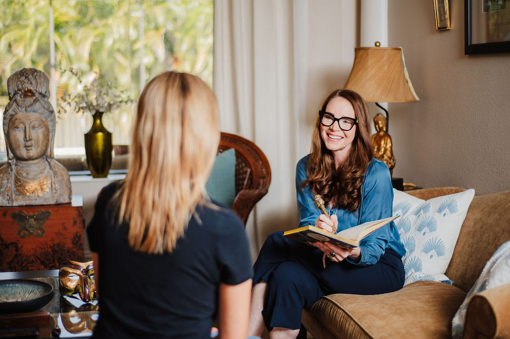 brand photo of therapist talking with patient and taking notes