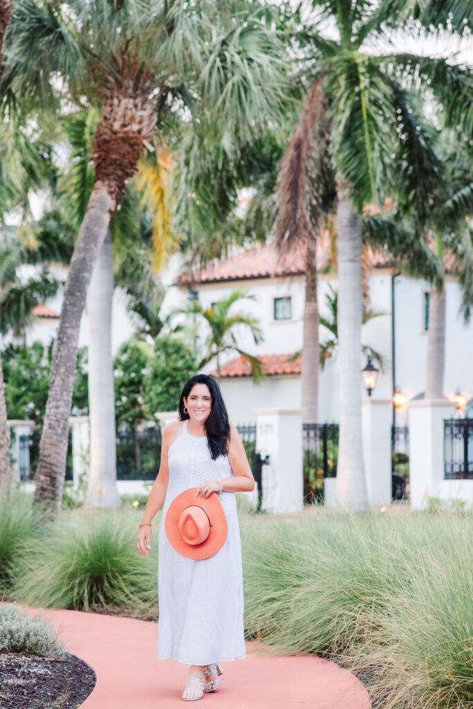 Brand image of life coach walking on sidewalk at Lido Beach with beautiful palm trees and white big house as a background