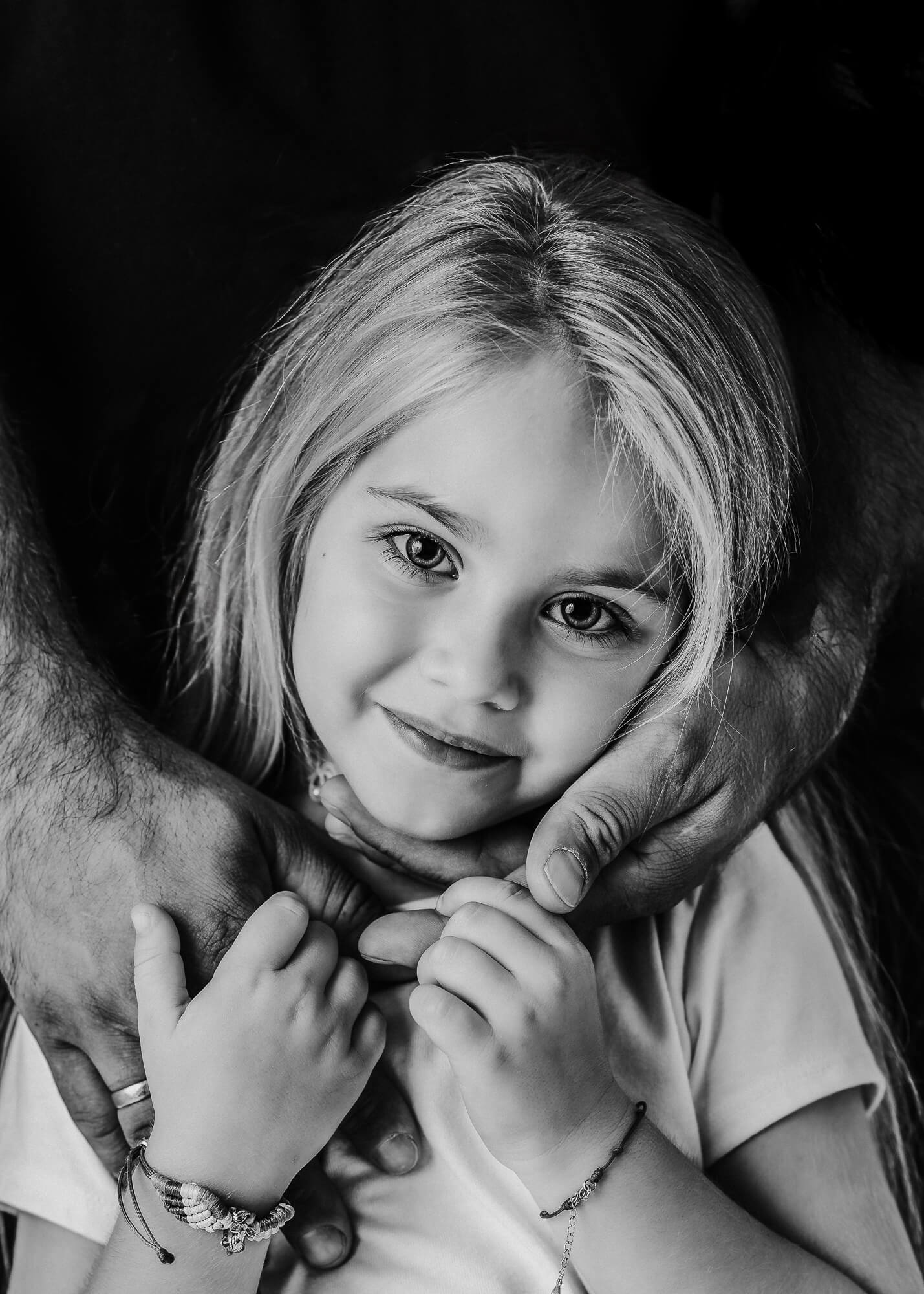 Portrait of small girl holding her dads hands