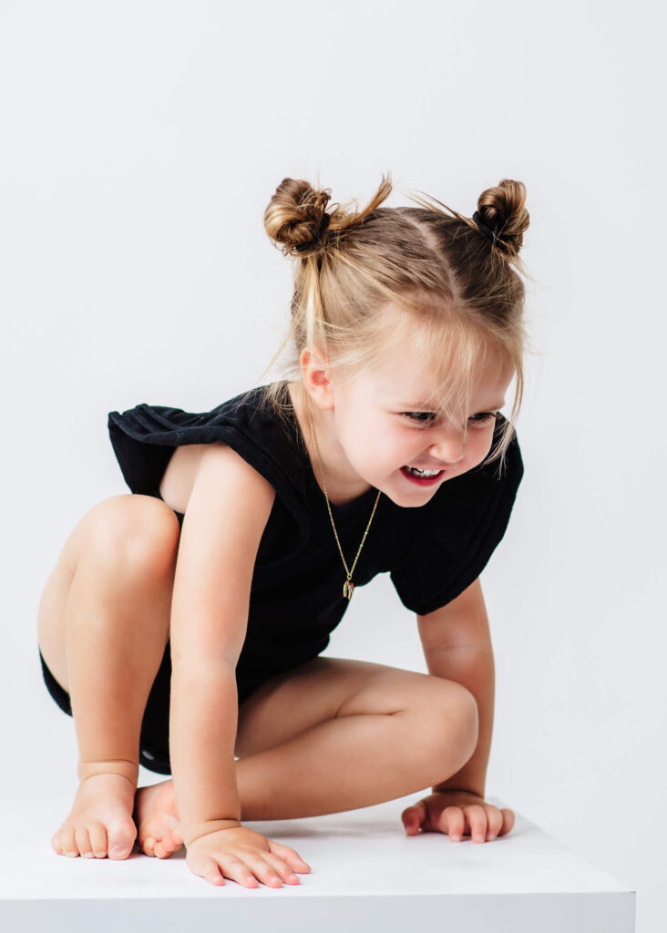 little girl wearing black outfit being silly