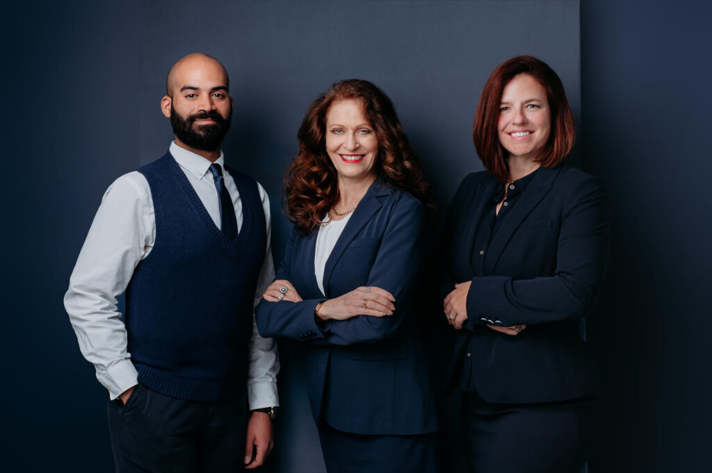 Team portrait of 3 business partners on the dark blue background